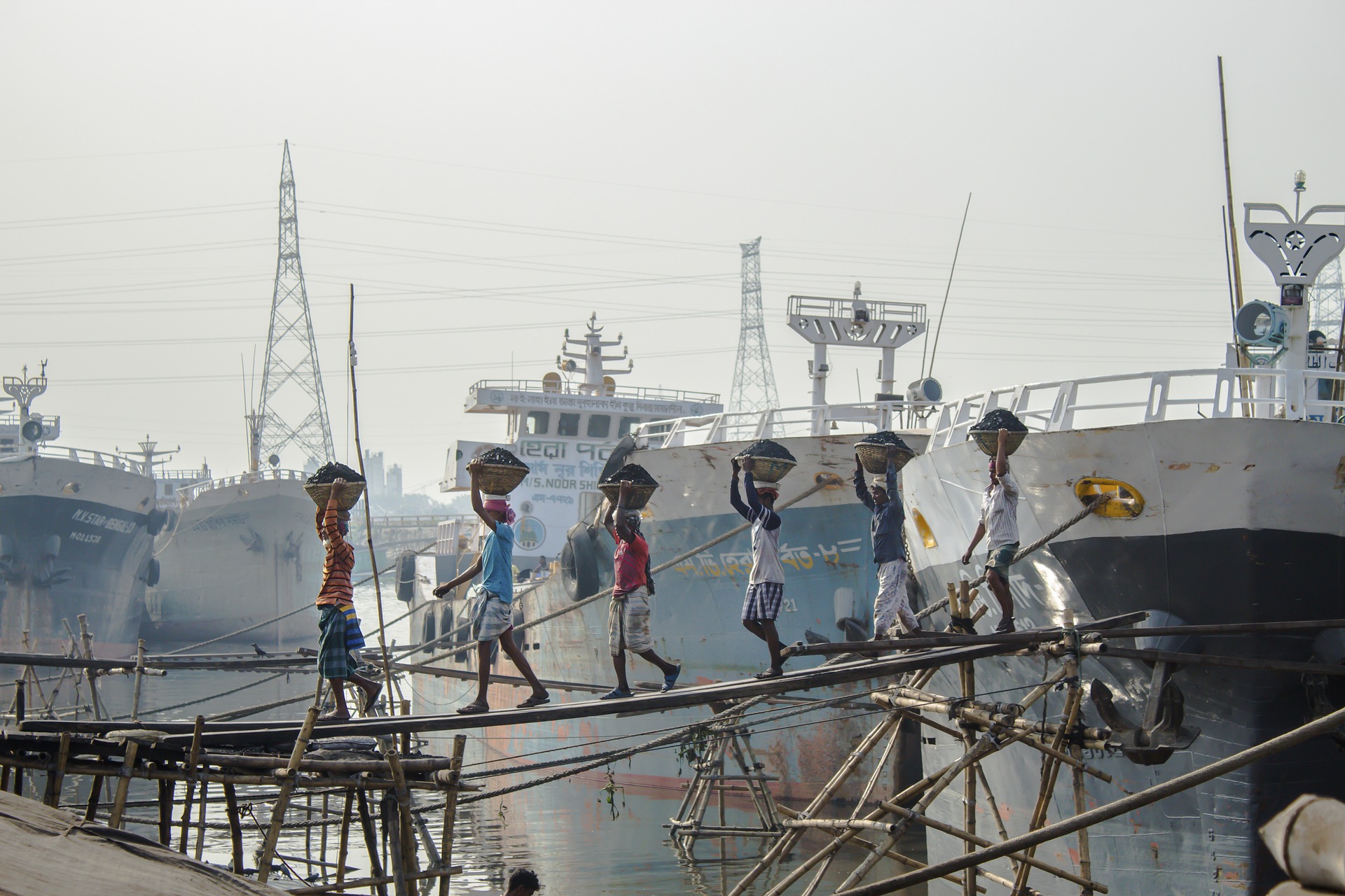 Workers carrying coal ash by the ships in Bangladesh. 