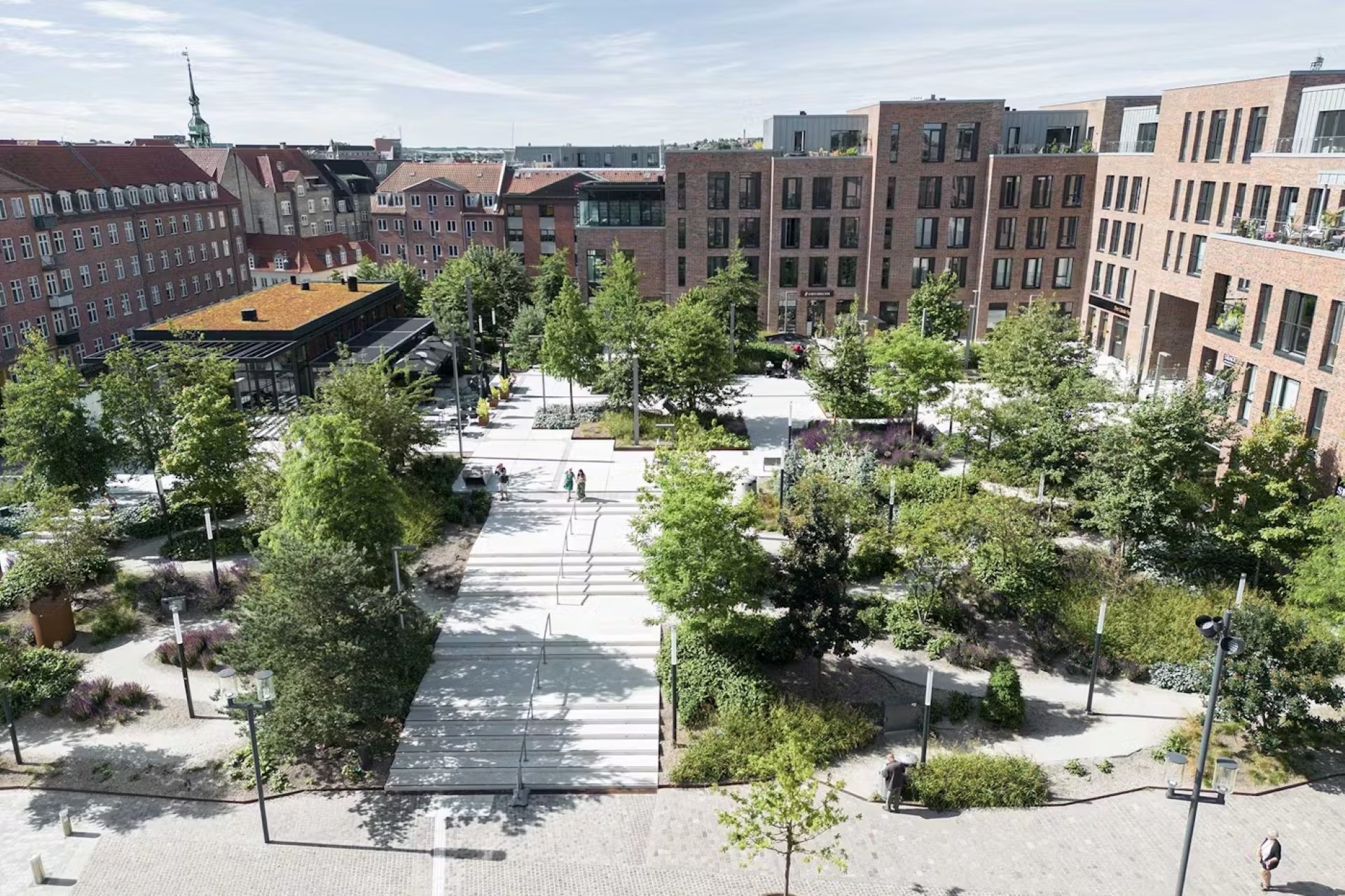 A wide view of Budolfi Square, a parking lot-turned-green space.