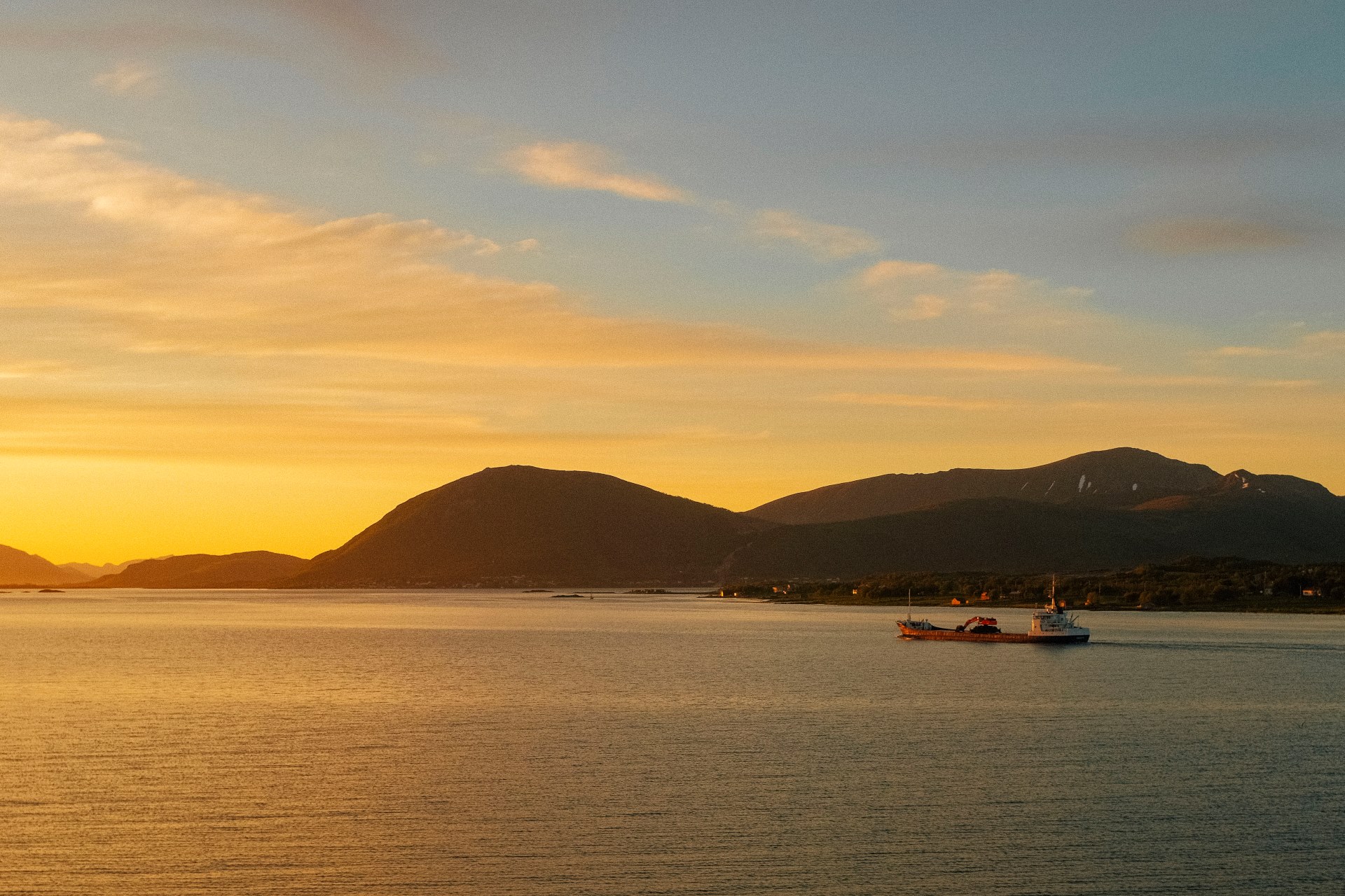 A ship sails into the midnight sun in Sortland. A postcard-like view in the contrast of the articles' content of Norway environmental problems.