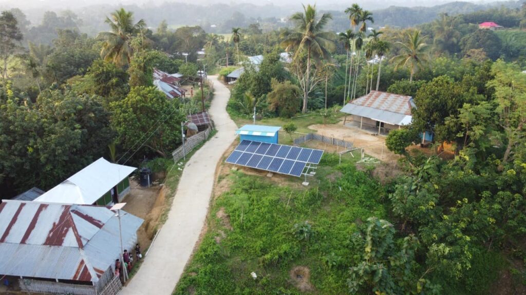 A photo of India's bio village called ’Bio Village 2.0 Solar Hamlet’ - a landscape of houses and solar panels surrounded by the Indian forest.
