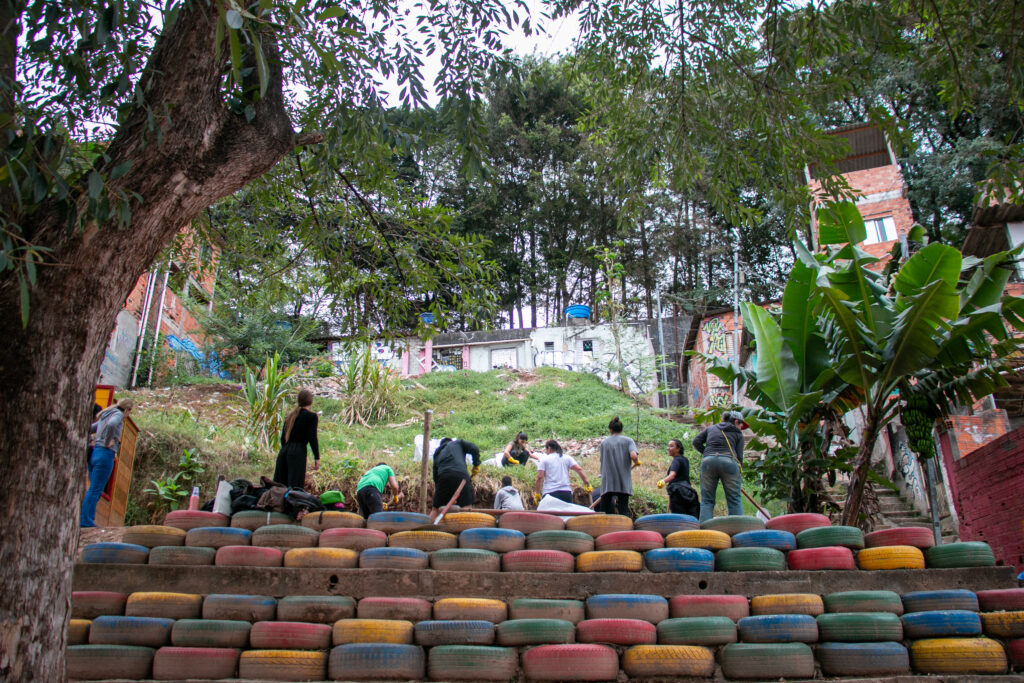 Photo of a group of people building the second terrain platform in Fazendinha using tires - example of circular design in favelas.