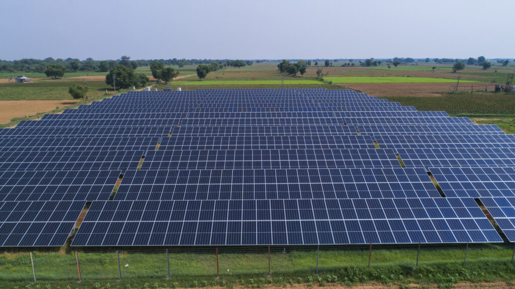 Photo of the solar plant set up in - lanes of solar panels in the field. 