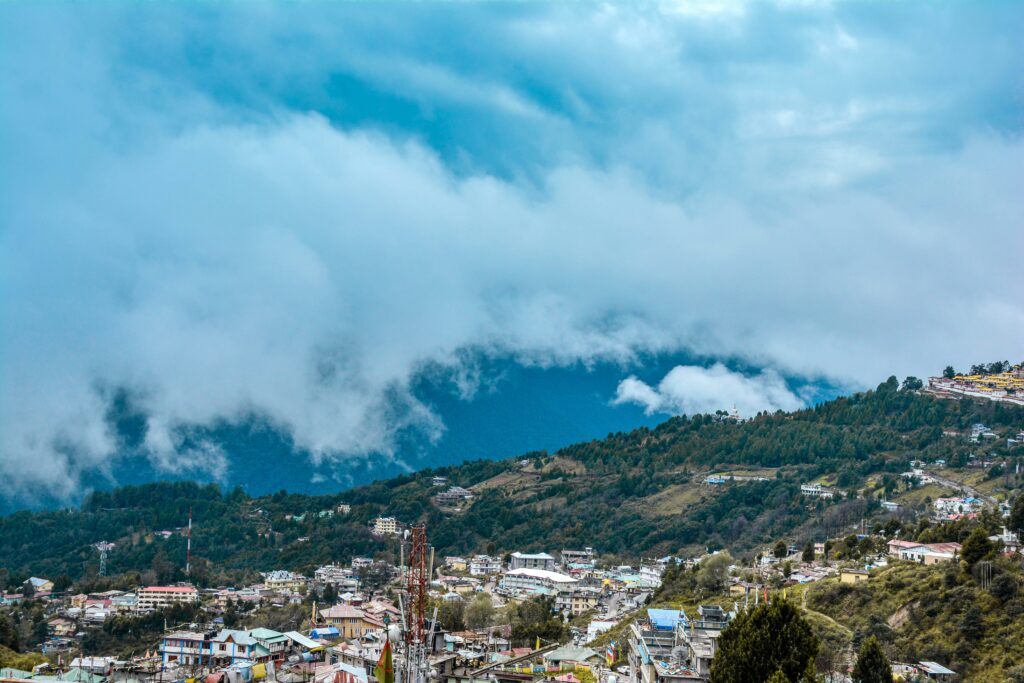 A landscape photo of the Arunachal Pradesh region. A city surrounded by a forests and the mountains.